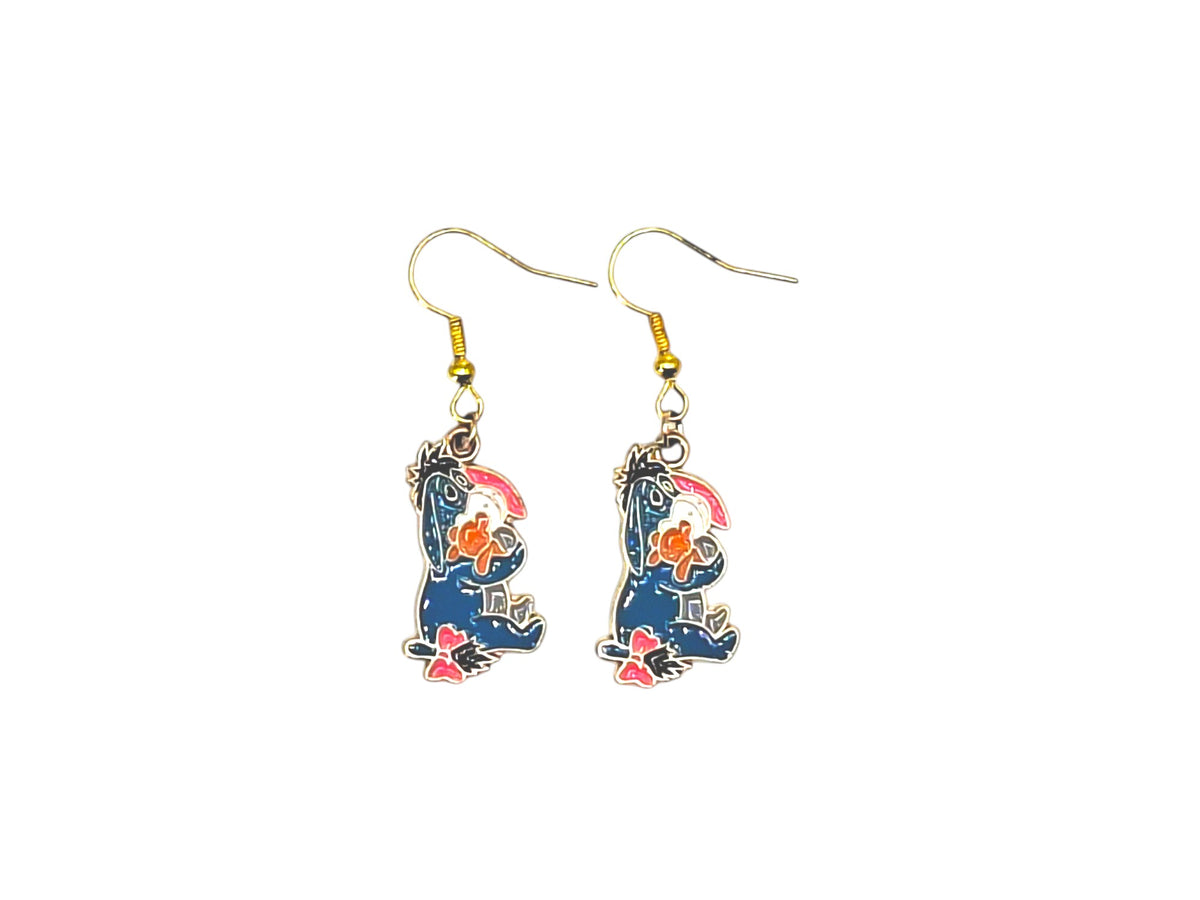 Boucles d’oreilles Bourriquet avec petite fleur colorée et crochets dorés sur fond blanc