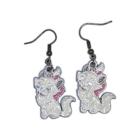 Boucles d’oreilles Marie inspirées des Aristochats en pose coquette, crochets noirs, sur fond blanc