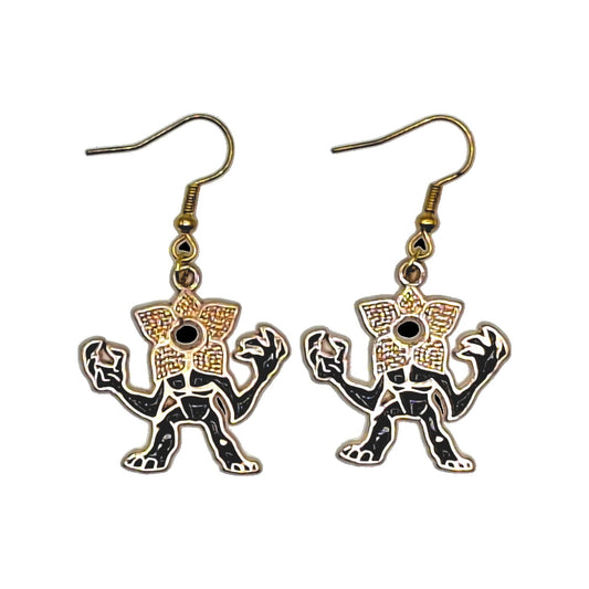 Demogorgon earrings inspired by Stranger Things, black-and-gold creature charms with gold-tone hooks on a white background