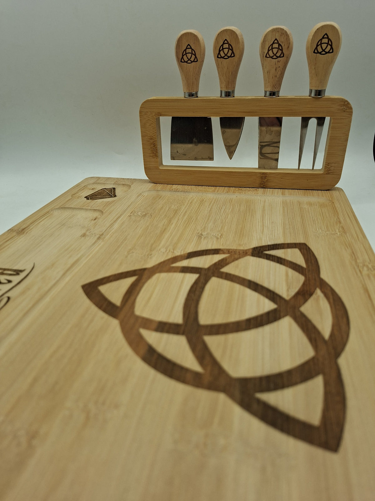 Détail de la gravure Charmed sur la planche à fromage et son support à couverts